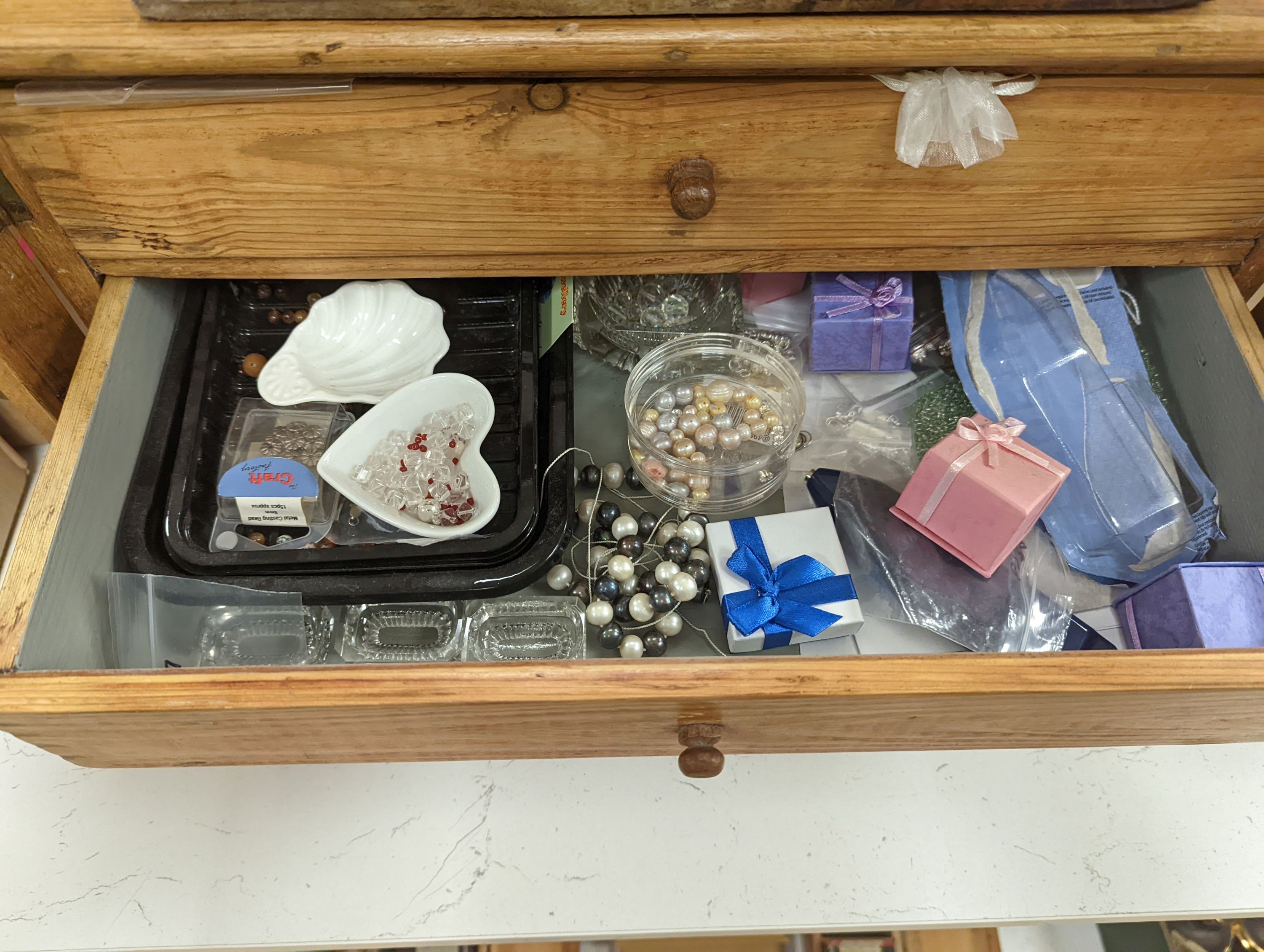 A 'Holdtite' shop cabinet and a pine three drawer chest, housing some costume jewellery